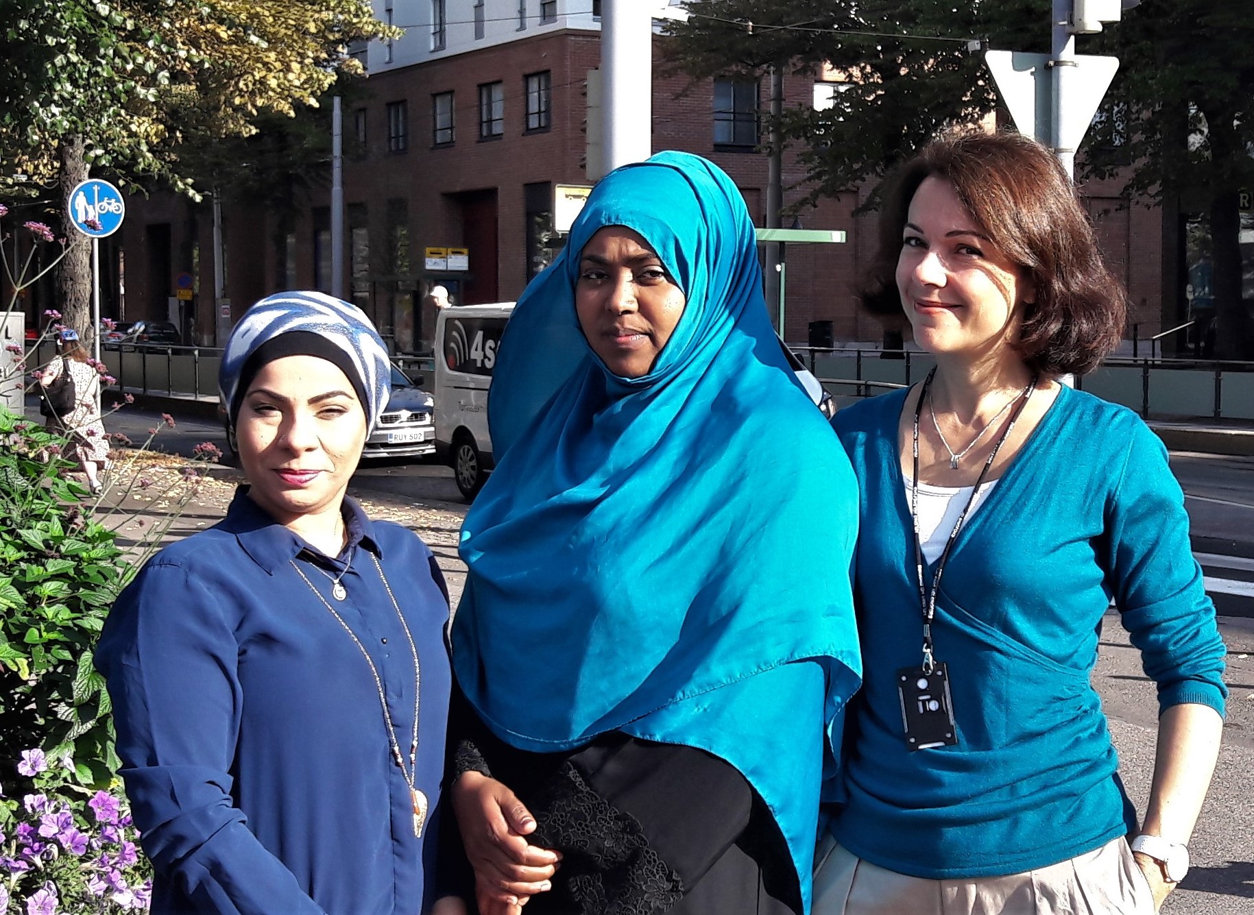 "Zainab Al-Ali, Suhuur Musse ja Marina Rinas seisovat rinnakkain, taustalla katumaisema."